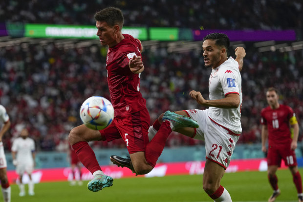 Denmark's Joakim Maehle, left, vies for the ball with Tunisia's Wajdi Kechrida during the World Cup group D soccer match between Denmark and Tunisia, at the Education City Stadium in Al Rayyan, Qatar, Tuesday, Nov. 22, 2022 
