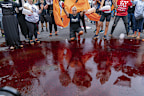 <p>The protesters poured red liquid onto the street, saying it symbolised the blood of those killed in Gaza.</p>