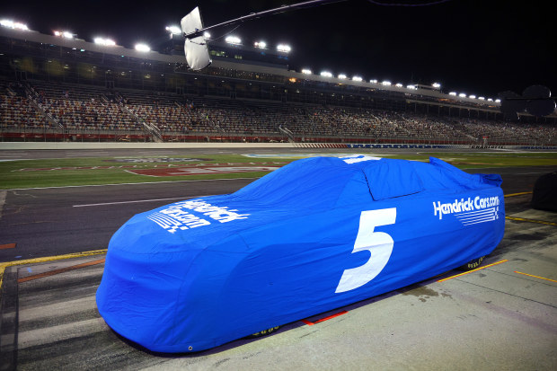 Kyle Larson's Chevrolet Camaro parked and covered during a weather delay in the NASCAR Cup Series Coca-Cola 600 at Charlotte Motor Speedway.