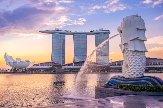 Silhouette of Merlion Statue at Marina Bay against the sunrise.
