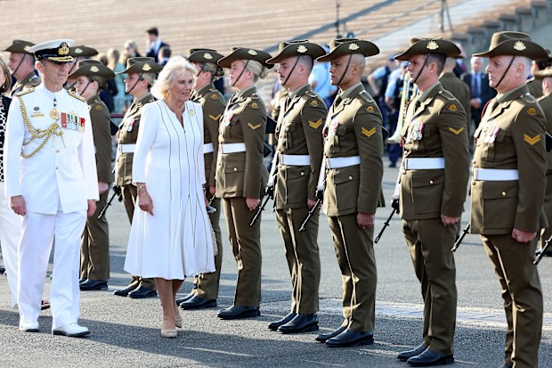 Queen Camilla and Chief of the Defence Force, Admiral David Johnston walk a Guard comprising selected members of Their Majesties' affiliated units, the 1st Armoured Regiment and the Royal Australian Corps of Military Police at the Sydney Opera House with the Sydney Harbour Bridge in the background on October 22, 2024 in Sydney, Australia. 