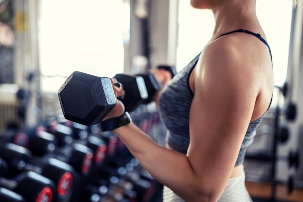 Young woman weightlifting at gym