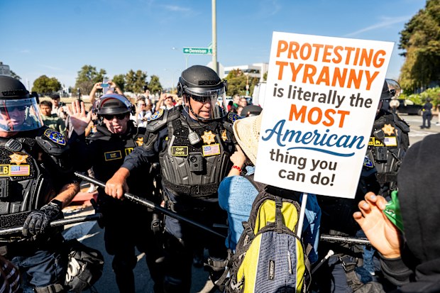 California Highway Patrol officers move back protesters who were blocking the entrance to Coast Guard Base Alameda on Thursday, Oct. 23, 2025, in Oakland, Calif. (AP Photo/Noah Berger)