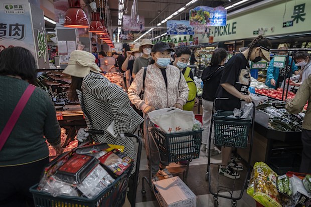 People crowd as they shop for food at a supermarket in Chaoyang District in Beijing, China