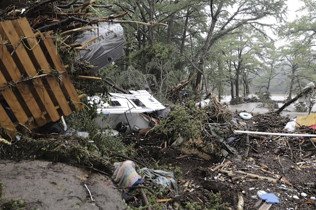 Damaged vehicles and debris are seen roped off near the banks of the Guadalupe River after flooding in Ingram, Texas.