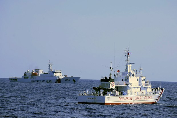 In this photo provided by the Philippine Coast Guard, a Chinese Coast Guard ship sails near a Philippine Coast Guard vessel during its patrol at Bajo de Masinloc, 124 nautical miles west of Zambales province, northwestern Philippines on March 2, 2022.  