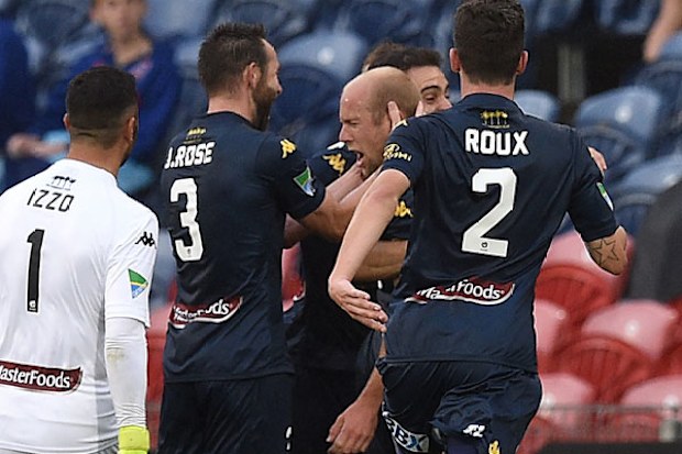 Goal scorer Matthew Simmed is mobbed by teammates. (AAP)