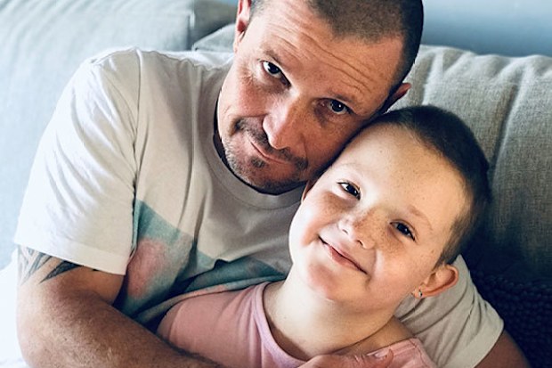 Charli Gerrey with her dad after shaving her head during cancer treatment.