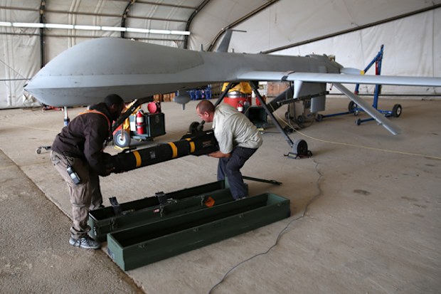 Contract workers load a Hellfire missile onto a US Air Force MQ-1B Predator unmanned aerial vehicle (UAV), at a secret air base in the Persian Gulf region. The US military and coalition forces use the base, located in an undisclosed location, to launch drone airstrikes against Islamic State in Iraq and Syria.