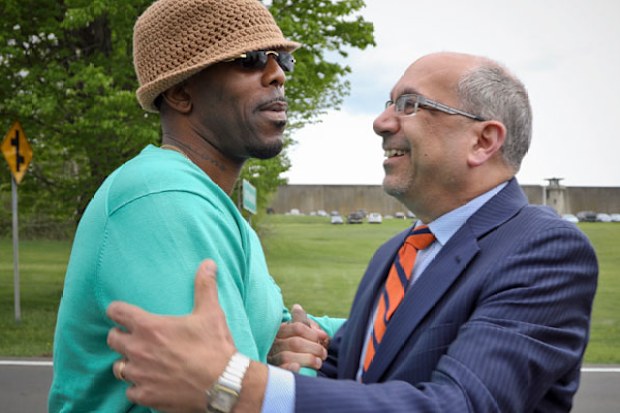 Calvin Buari, left, is embraced by his lawyer Oscar Michelen following Buari's release from prison last year. (AP).