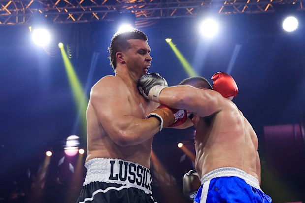 Paul Gallen (R) lands a punch on the jaw of Darcy Lussick.