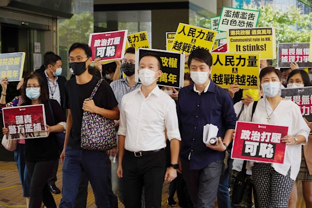 Pro-democracy politicinas, second from left, Eddie Chu, Raymond Chan and Eddie Chu walk with supporters at a local court in Hong Kong. They  appeared in court one day after they were arrested for disrupting the legislature during debate on a national anthem bill earlier this year. (AP Photo/Vincent Yu)
