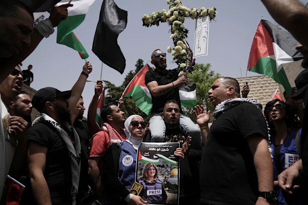 Mourners gather at the hospital where the body of slain Al Jazeera veteran journalist Shireen Abu Akleh will be taken from to to her final resting place, in east Jerusalem, Friday, May 13, 2022. Abu Akleh, a Palestinian-American reporter who covered the Mideast conflict for more than 25 years, was shot dead Wednesday during an Israeli military raid in the West Bank town of Jenin.(AP Photo/Mahmoud Illean)