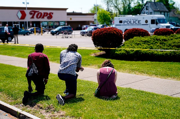 People pray outside the supermarket in Buffalo.