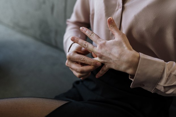 Stock photo of a woman removing her wedding ring, divorce.