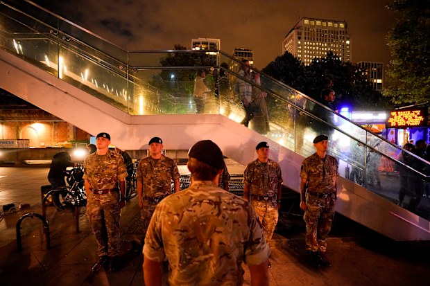 British servicemen observe a "National moment of reflection" in honour of the late Queen Elizabeth II, the day before her funeral, in London, Sunday, Sept. 18, 2022. 