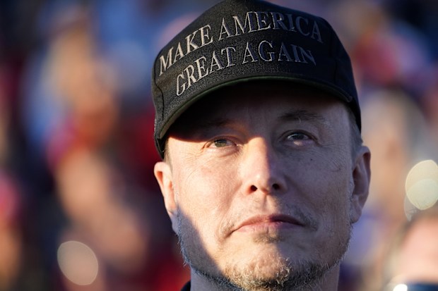 FILE - Tesla and SpaceX CEO Elon Musk listens as Republican presidential nominee former President Donald Trump speaks at a campaign event at the Butler Farm Show, Oct. 5, 2024, in Butler, Pa. (AP Photo/Alex Brandon, File)