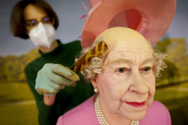The wax figure of Queen Elizabeth II is bald underneath her hat.
