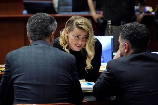 Actress Amber Heard talks to her attorneys in the courtroom at the Fairfax County Circuit Court in Fairfax, Va., Monday April 18, 2022. Actor Johnny Depp sued his ex-wife Amber Heard for libel in Fairfax County Circuit Court after she wrote an op-ed piece in The Washington Post in 2018 referring to herself as a "public figure representing domestic abuse." (AP Photo/Steve Helber, Pool)