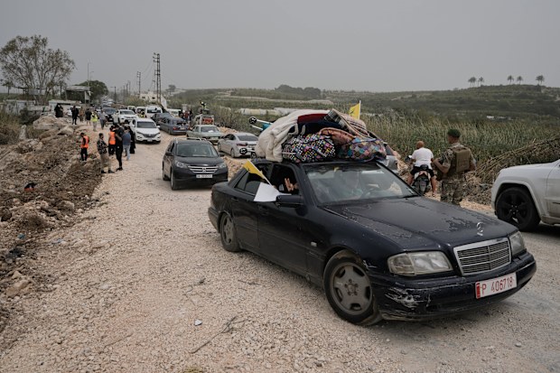 Displaced people cross a destroyed bridge while returning to their villages on the second day of a ceasefire between Hezbollah and Israel in Qasmiyeh, near Tyre city, southern Lebanon.
