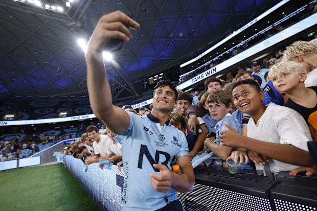 Joseph-Aukuso Suaalii of the Waratahs takes selfies with fans.