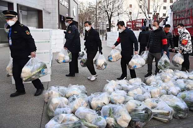 In this photo released by Xinhua News Agency, subdistrict office staff carry daily necessities to be delivered to households under closed-off management in Xi'an, in northwestern China's Shaanxi Province, Dec. 29, 2021. Chinese officials promised steady deliveries of groceries to residents of Xian, an ancient capital with 13 million people that is under the strictest lockdown of a major Chinese city since Wuhan was shut early last year at the start of the pandemic. (Liu Xiao/Xinhua via AP)
