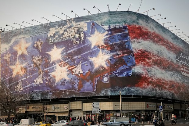 A billboard depicting a damaged US aircraft carrier with disabled fighter jets on its deck and a sign reading in Farsi and English, "If you sow the wind, you'll reap the whirlwind," is seen at Enqelab-e-Eslami (Islamic Revolution) Square in Tehran. Iran has blamed foreign powers, including the USA, for the recent unrest and protests.