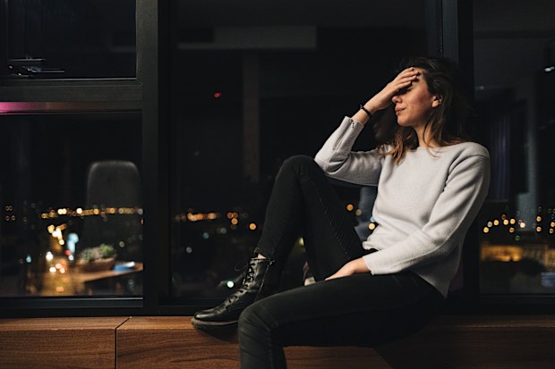 Abused young woman sitting in her room alone crying after being abused