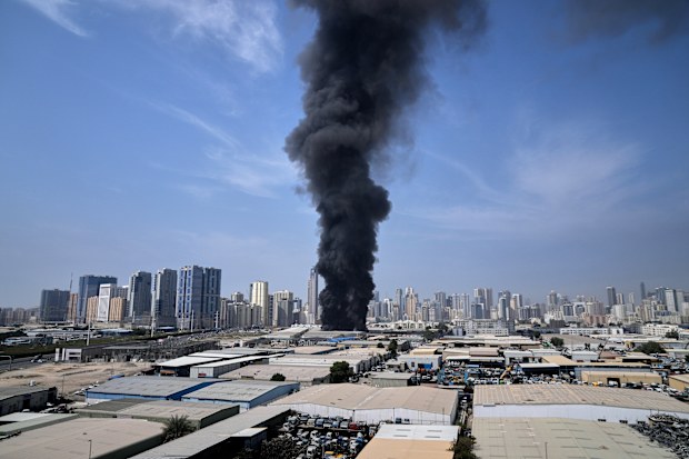 A black plume of smoke rises from a warehouse at the industrial area of Sharjah City in the United Arab Emirates following reports of Iranian strikes in Dubai, United Arab Emirates, Sunday, March 1, 2026. (AP Photo/Altaf Qadri)