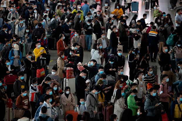 Travellers wearing face masks to protect against COVID-19 wait for their trains at a train station in Guangzhou in southern China's Guangdong Province, Friday, Jan. 28, 2022.  
