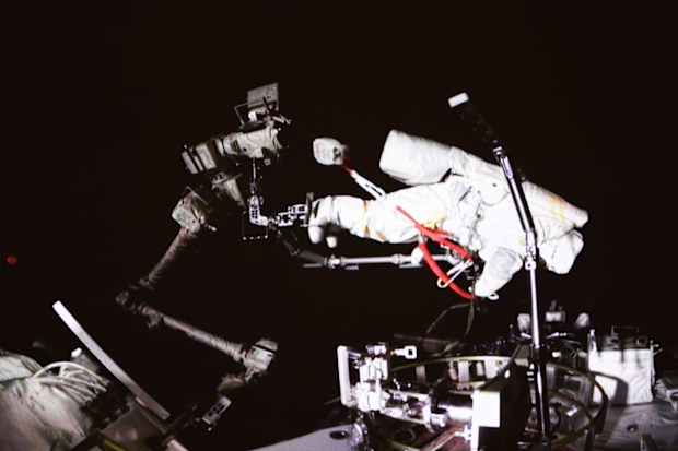 Chinese astronaut Cai Xuzhe conducting extravehicular activities, also known as a spacewalk.