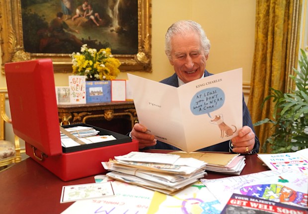 In this photo released on February 23, King Charles III reads cards and messages, sent by well-wishers following his cancer diagnosis, in the 18th Century Room of the Belgian Suite at Buckingham Palace on February 21, 2024 in London, England.