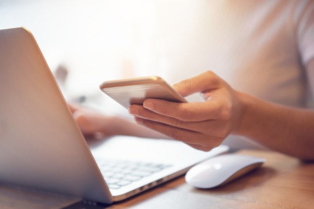 woman using phone and computer