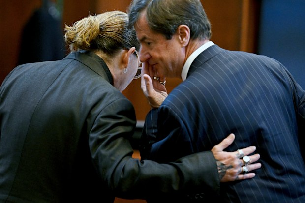US actor Johnny Depp speaks to his attorney Ben Chew in the courtroom at the Fairfax County Circuit Court in Fairfax, Virginia, on May 3, 2022.