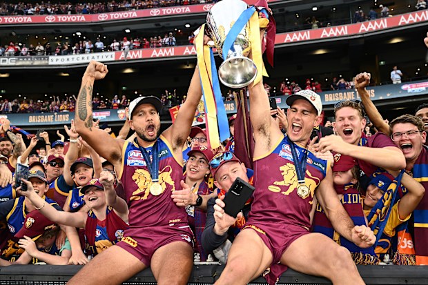 Callum Ah Chee and Brandon Starcevich of the Lions celebrate with the premiership cup.