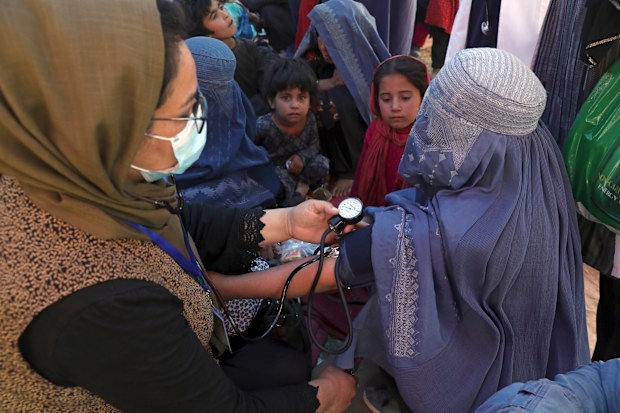 Internally displaced Afghan women from northern provinces, who fled their home due to fighting between the Taliban and Afghan security personnel, receive medical care in a public park in Kabul earlier this month.