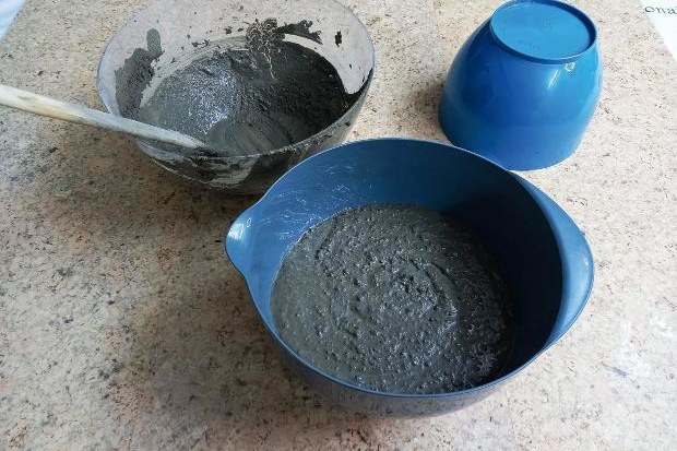 Mixing concrete for DIY plant pots.