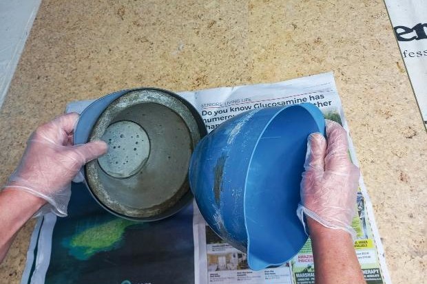 Mould removed from concrete during DIY plant pot project.