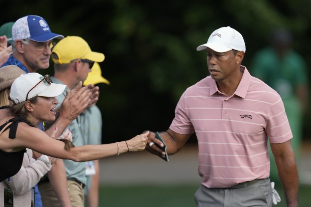 Tiger Woods greets a patron on the sixth hole.
