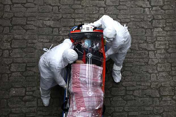 Medical staff, wearing protective gear, move a patient infected with the coronavirus from an ambulance to a hospital in Seoul, South Korea.