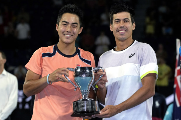 Rinky Hijikata, left, of Australia and compatriot Jason Kubler pose with their trophy after defeating Hugo Nys of Monaco and Jan Zielinski of Poland in the men's doubles final at the Australian Open.