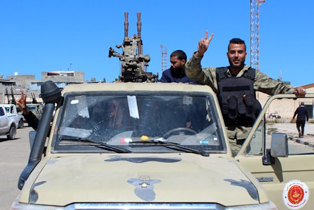 Militants, reportedly from the Misrata militia, flash the victory sign as they gather before heading to the frontline to join forces defending the capital, in Tripoli, Libya