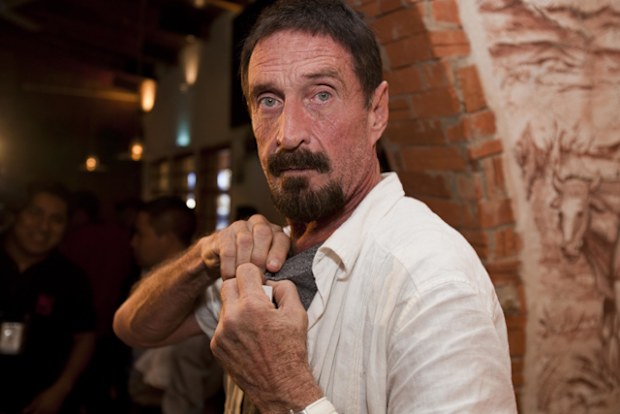Software company founder John McAfee adjusts a microphone in preparation for an interview in Guatemala City.