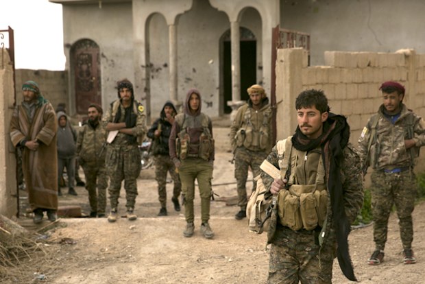 US-backed Syrian Democratic Forces fighters wait to go to the front line to oust Islamic State militants from Baghouz, Syria, in a photo dated March 14, 2019.