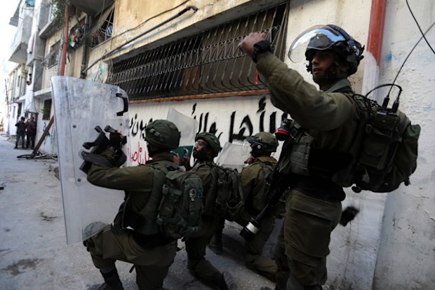 Israeli soldiers take position at Aroub refugee camp, north of the West Bank city of Hebron