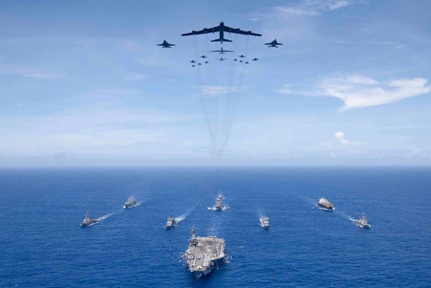 The aircraft carrier USS Ronald Reagan leads a formation of Carrier Strike Group 5 ships as US Air Force B-52 Stratofortress aircraft and US Navy F/A-18 Hornets fly over head