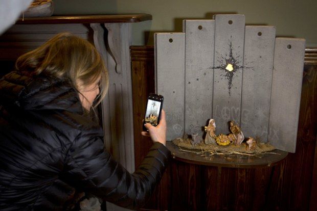 Banksy wants people celebrating Christmas to consider what's happening in present-day Bethlehem. The elusive street artist's latest work features a "modified nativity" scene: Joseph and Mary kneeling beside Jesus in a manger set beside a monstrous concrete wall. The wall appears to be pierced by a mortar shell, leaving a mark that resembles a guiding star. Graffitied on the wall are the words "love" and "peace," in English and French.