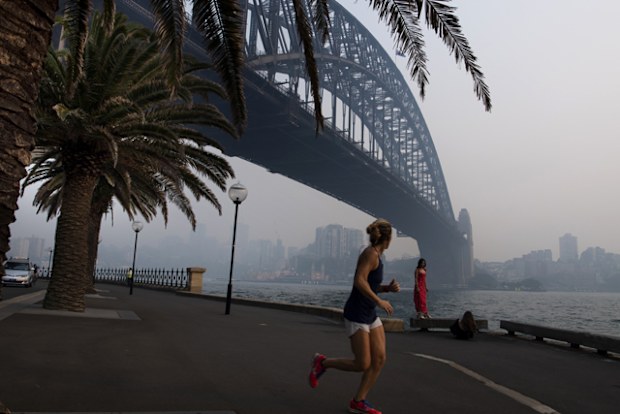 A jogger runs along the waterfront as smoke haze from bushfires sits over the harbour bridge.