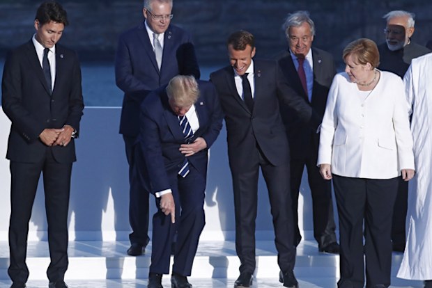 US President Donald Trump makes a joke during the 'family photo' at the G7 summit. Standing around Mr Trump are Canadian Prime Minister Justin Trudeau, French President Emmanuel Macron, German Chancellor Angela Merkel, Australian Prime Minister Scott Morrison, UN Secretary General Antonio Guterres and Indian Prime Minister Narendra Modi