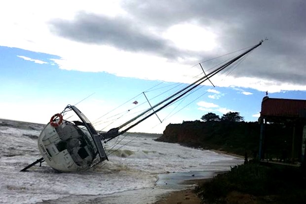 A yacht battered by high winds and seas washes up at Mills Beach, Victoria. Source: 